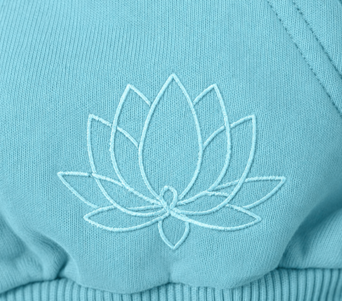Close-up of the embroidered lotus emblem on the Lotus Blue cropped zip-up hoodie.