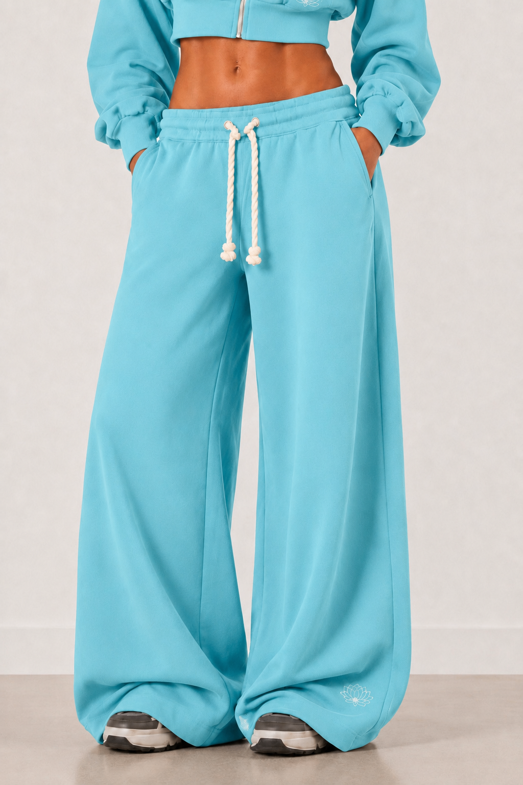 Front view of the Lotus Blue wide-leg tracksuit bottoms with contrast rope drawcord.